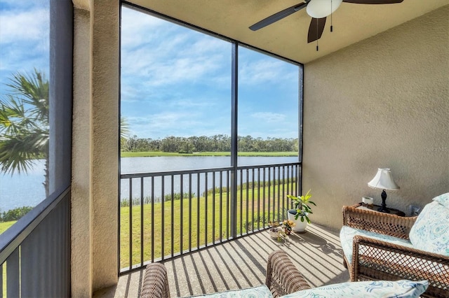 sunroom / solarium featuring ceiling fan and a water view