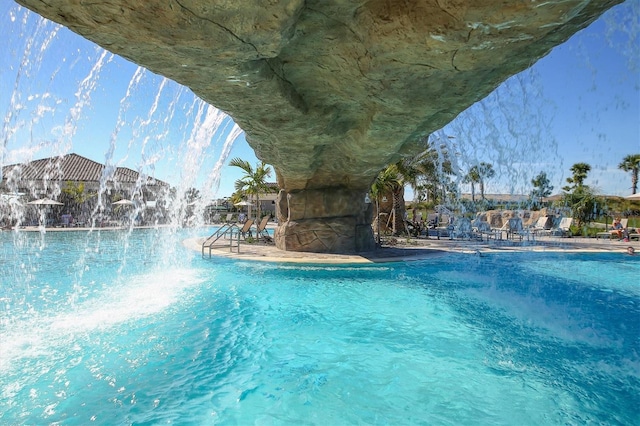 view of swimming pool with pool water feature