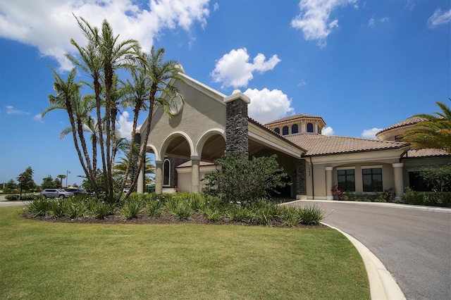 mediterranean / spanish house with a garage and a front yard