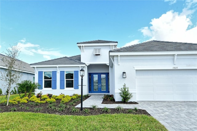 15625 San Lazzaro Ave, Bradenton, FL 34211 - view of front of home featuring french doors, an attached garage, decorative driveway, stucco siding, and a tile roof