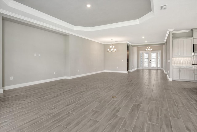 15625 San Lazzaro Ave, Bradenton, FL 34211 - unfurnished living room with a chandelier, ornamental molding, a tray ceiling, wood finished floors, and recessed lighting