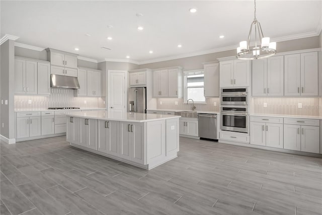 15625 San Lazzaro Ave, Bradenton, FL 34211 - kitchen with appliances with stainless steel finishes, under cabinet range hood, a chandelier, backsplash, and crown molding