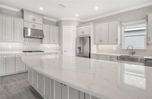 15625 San Lazzaro Ave, Bradenton, FL 34211 - kitchen with under cabinet range hood, high end refrigerator, gas stovetop, light stone counters, and decorative backsplash