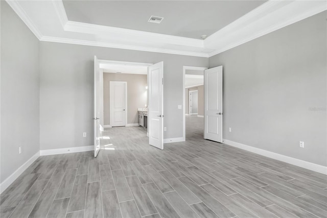 15625 San Lazzaro Ave, Bradenton, FL 34211 - unfurnished bedroom featuring a raised ceiling, ornamental molding, and light wood-style flooring
