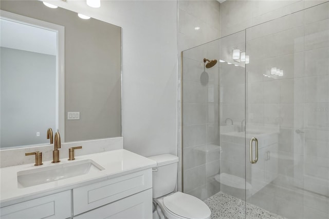 bathroom featuring vanity, an enclosed shower, and toilet