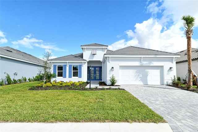 view of front of house featuring a garage, a front lawn, and french doors