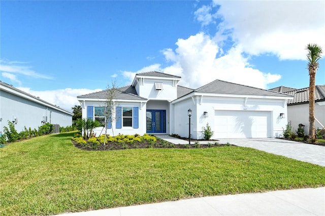 view of front of property featuring french doors, a garage, and a front lawn