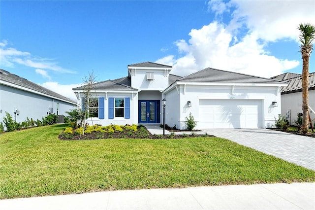 15625 San Lazzaro Ave, Bradenton, FL 34211 - view of front facade featuring french doors, a garage, a front lawn, decorative driveway, and stucco siding