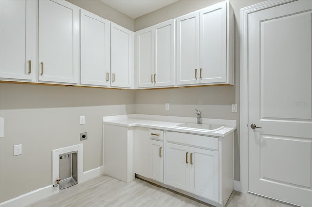 laundry area featuring cabinets, hookup for an electric dryer, and sink