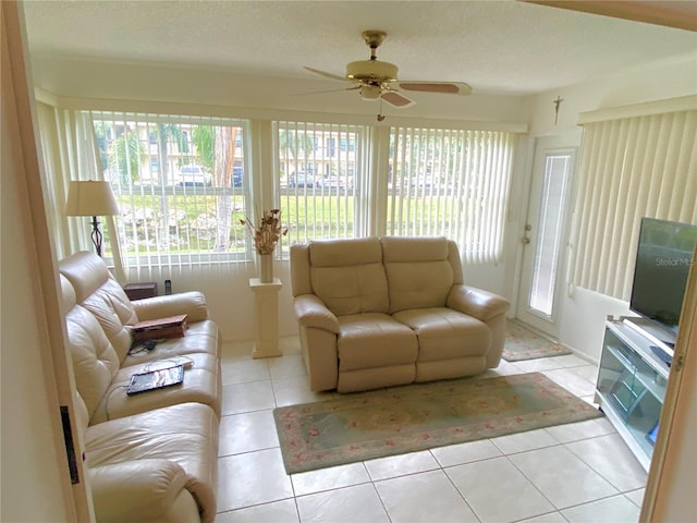 living room featuring ceiling fan, a textured ceiling, and light tile patterned floors