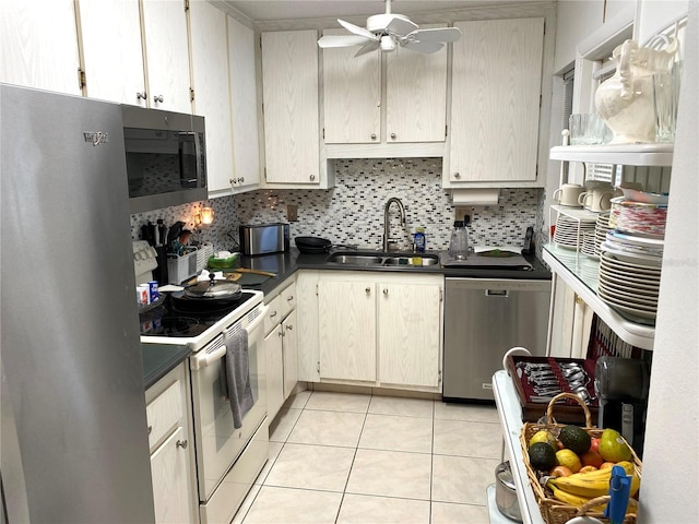 kitchen featuring stainless steel appliances, sink, tasteful backsplash, light tile patterned floors, and ceiling fan