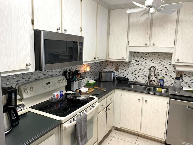 kitchen with decorative backsplash, sink, ceiling fan, light tile patterned flooring, and appliances with stainless steel finishes