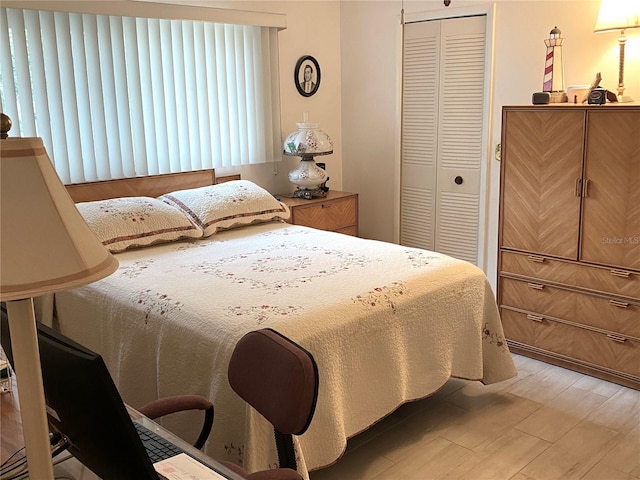 bedroom with light hardwood / wood-style floors and a closet