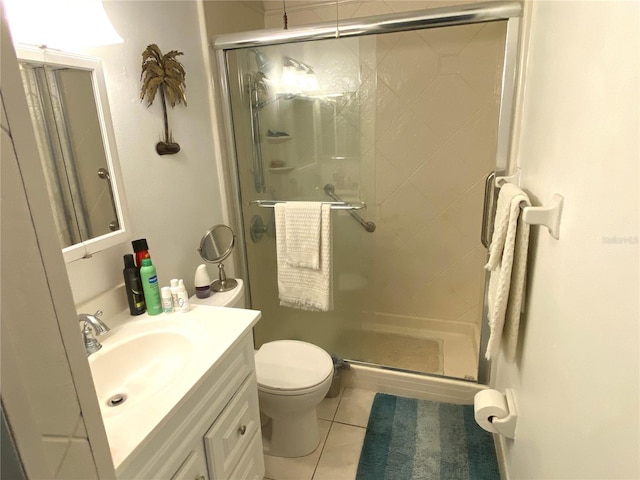 bathroom featuring toilet, vanity, an enclosed shower, and tile patterned flooring