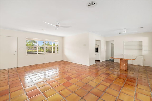 empty room with ceiling fan, light tile patterned floors, and ornamental molding