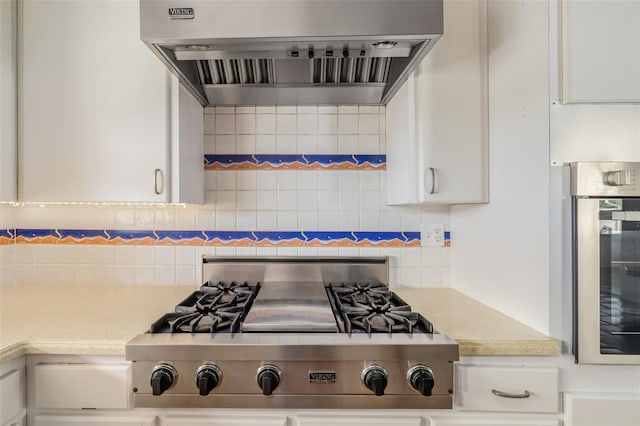 kitchen with white cabinets, wall chimney range hood, decorative backsplash, and stainless steel appliances