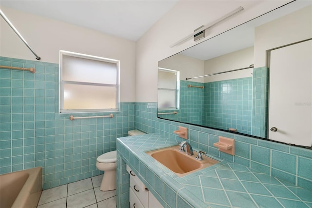 full bathroom featuring toilet, vanity, tile walls, and tile patterned flooring