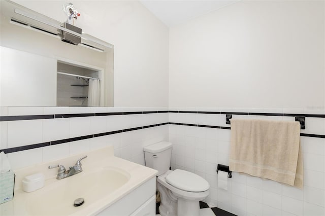 bathroom featuring tile walls, vanity, and toilet