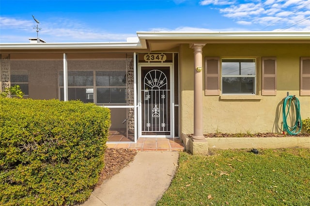 doorway to property with a lawn