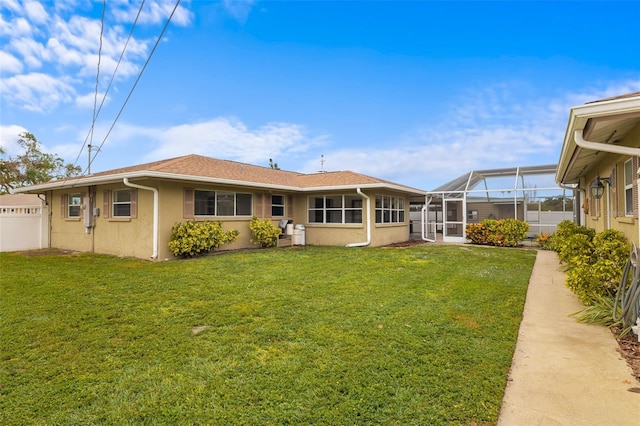 rear view of property with a lawn and a lanai