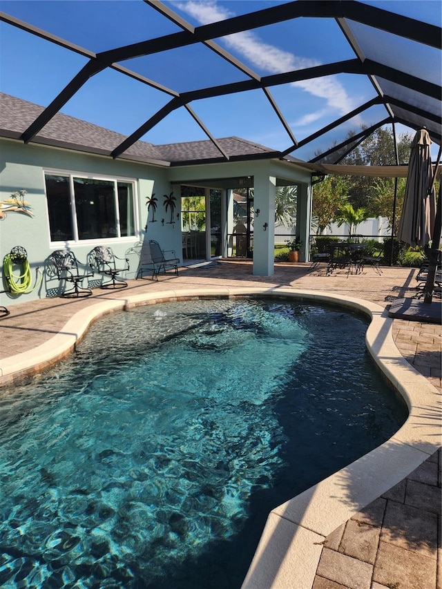 view of swimming pool with a patio and glass enclosure