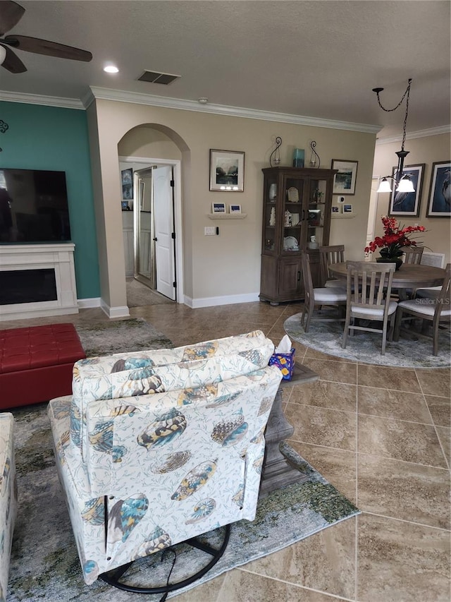 living room with ceiling fan and crown molding