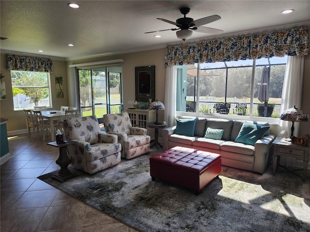 living room featuring dark tile patterned flooring, a textured ceiling, ceiling fan, and crown molding