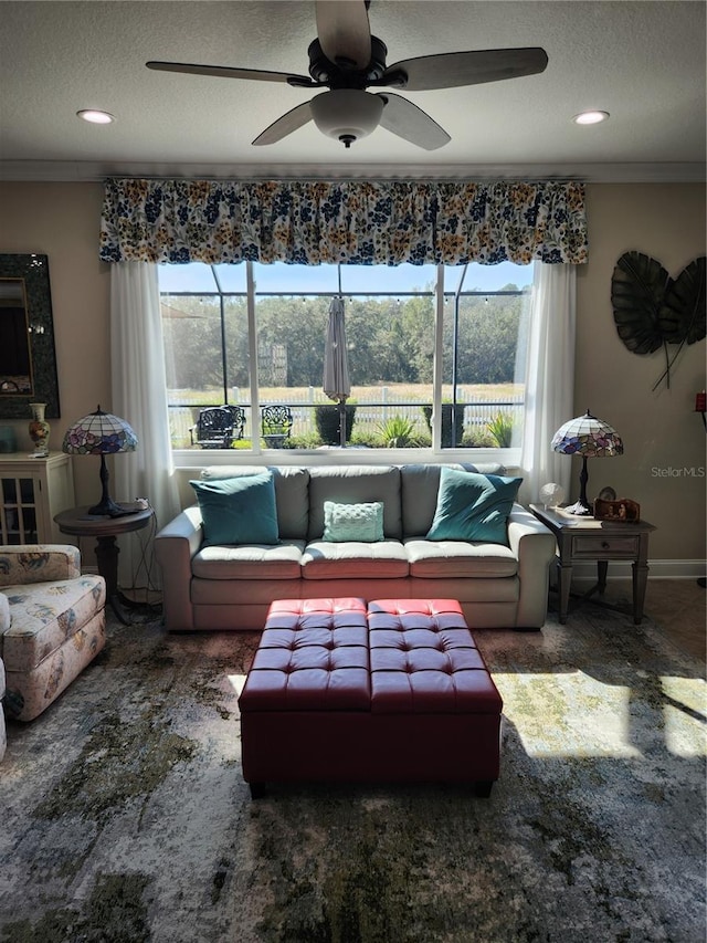 living room featuring plenty of natural light, ceiling fan, and crown molding