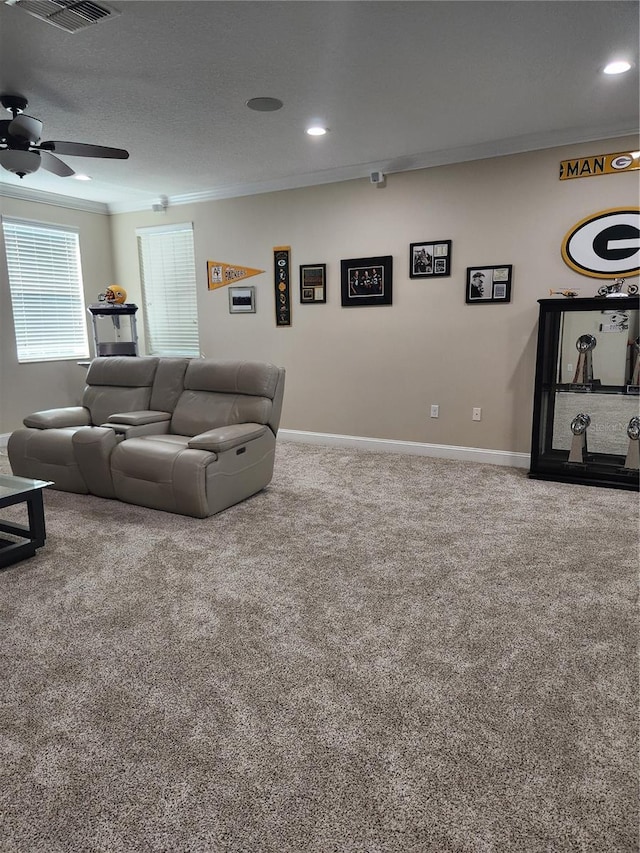 living room featuring carpet, a textured ceiling, ceiling fan, and crown molding