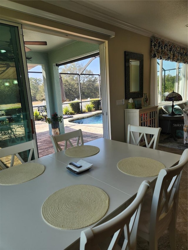 dining room featuring ceiling fan, a healthy amount of sunlight, and crown molding