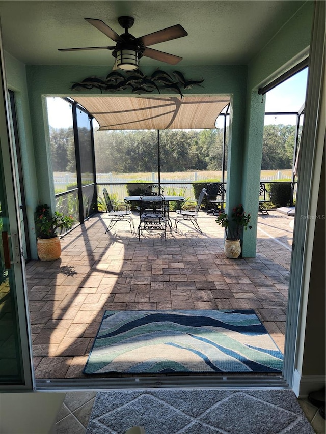 view of patio featuring ceiling fan and a lanai