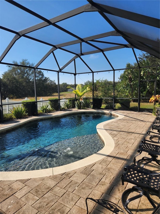 view of pool with glass enclosure, a patio, and pool water feature