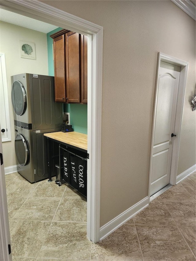 washroom featuring cabinets and stacked washer / dryer