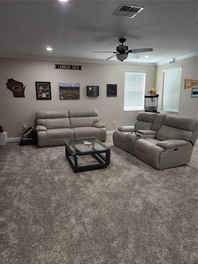 living room with ceiling fan, a textured ceiling, carpet flooring, and ornamental molding