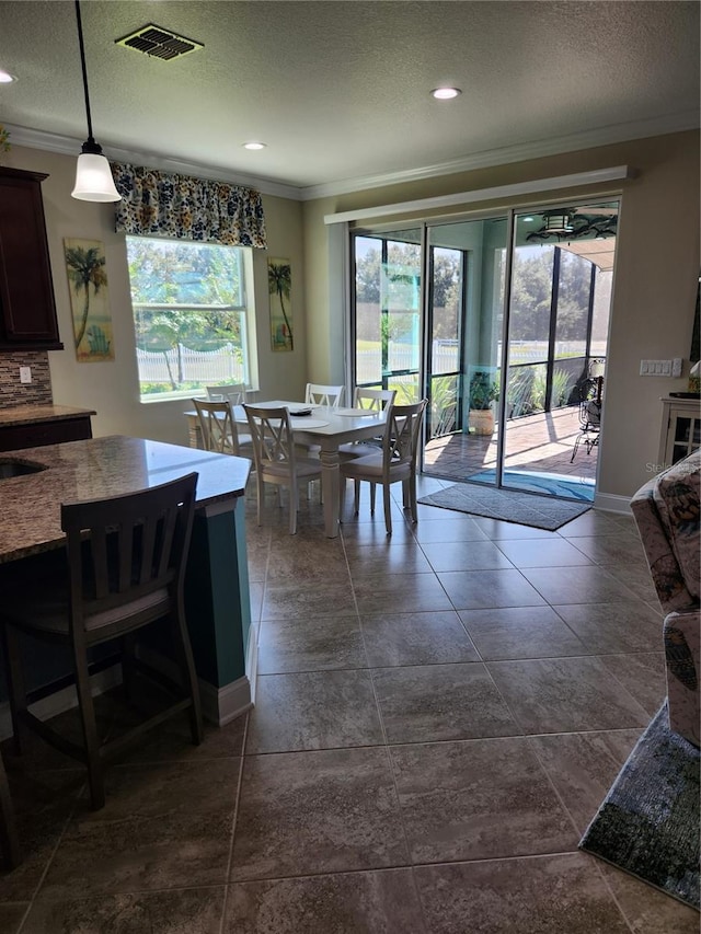 dining area with a textured ceiling and crown molding