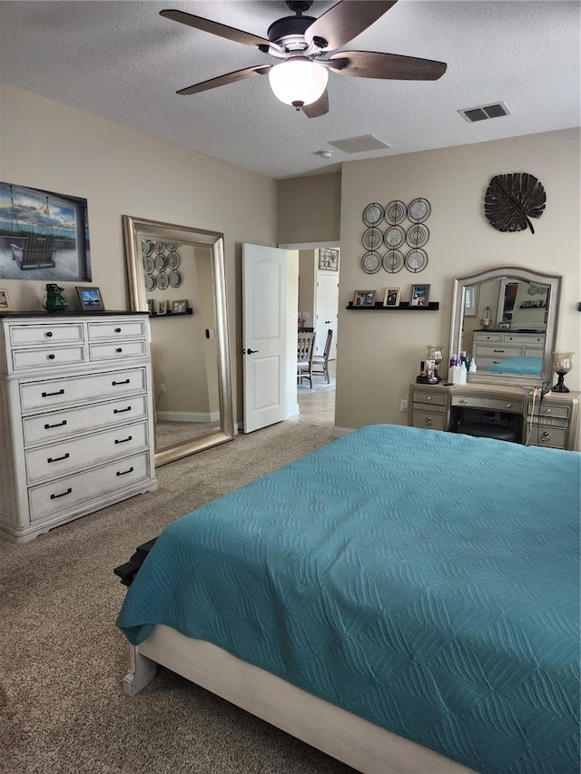 bedroom featuring a textured ceiling, light carpet, and ceiling fan