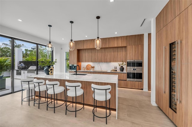 2038 Datura St, Sarasota, FL 34239 - kitchen featuring brown cabinetry, modern cabinets, a sink, and stainless steel double oven
