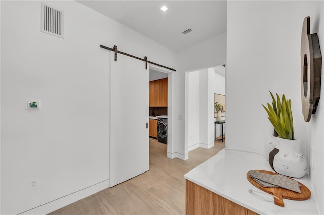 2038 Datura St, Sarasota, FL 34239 - corridor featuring washer / clothes dryer, a barn door, and visible vents