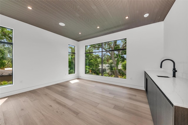 2038 Datura St, Sarasota, FL 34239 - unfurnished dining area with light wood-style floors, plenty of natural light, and a sink