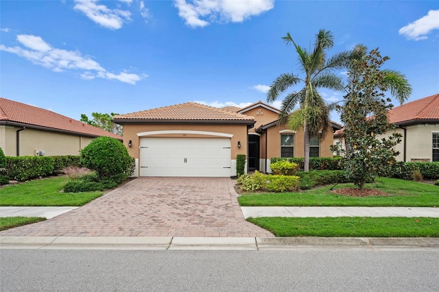 mediterranean / spanish-style home featuring a garage and a front lawn