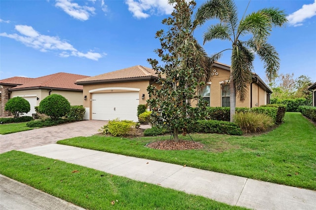 mediterranean / spanish-style house with a garage and a front lawn