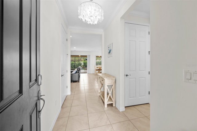 tiled entryway with an inviting chandelier and ornamental molding