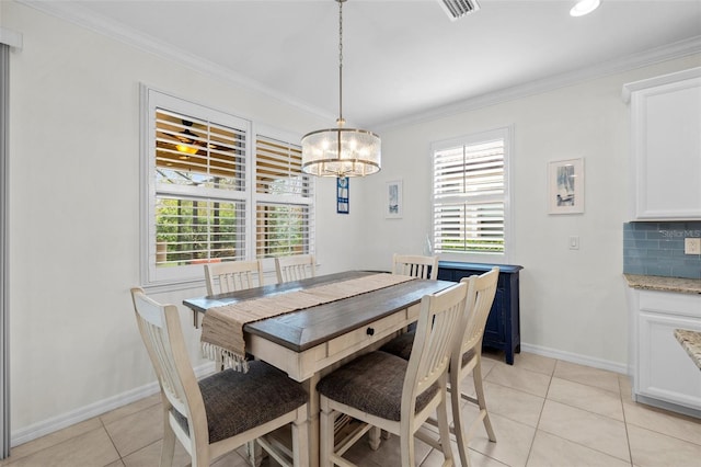 tiled dining area with a chandelier and crown molding