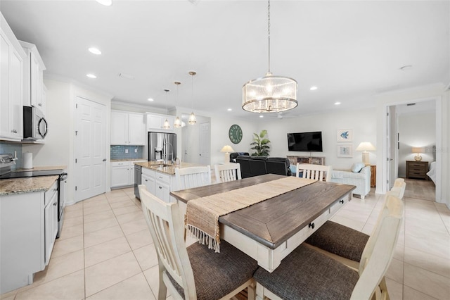 tiled dining area featuring a notable chandelier and sink