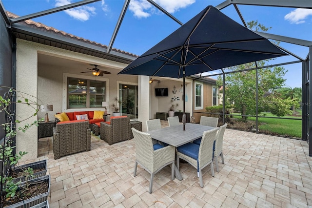 view of patio with ceiling fan, glass enclosure, and an outdoor hangout area