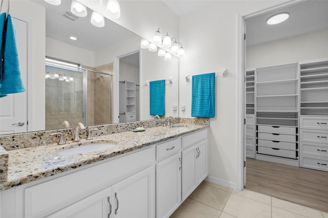 bathroom with hardwood / wood-style floors, walk in shower, and vanity