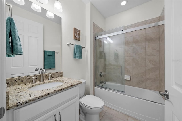 full bathroom with toilet, bath / shower combo with glass door, vanity, and tile patterned floors