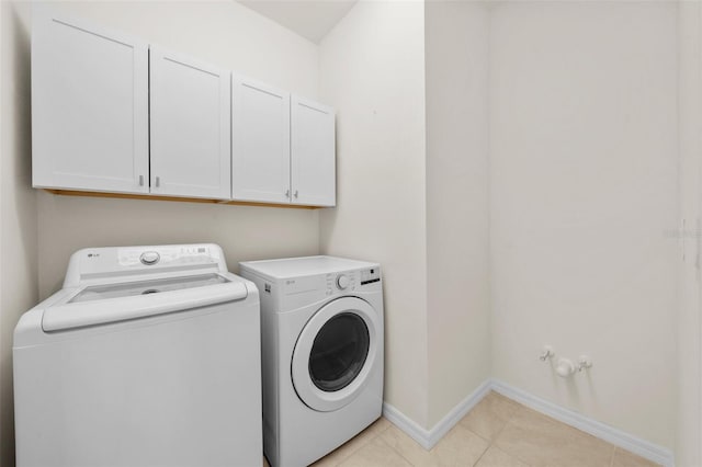 laundry area with cabinets, separate washer and dryer, and light tile patterned flooring