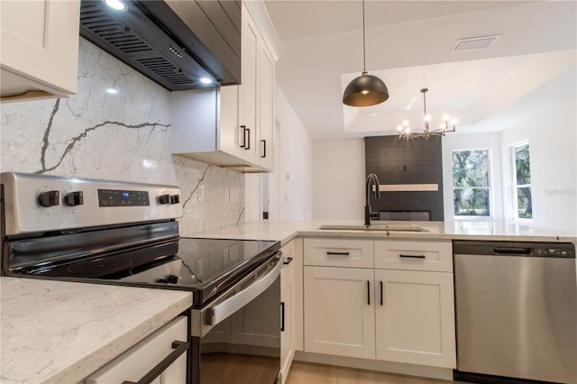 kitchen featuring sink, tasteful backsplash, white cabinetry, appliances with stainless steel finishes, and premium range hood