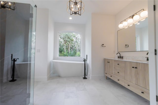 bathroom featuring a chandelier, vanity, and a bathing tub